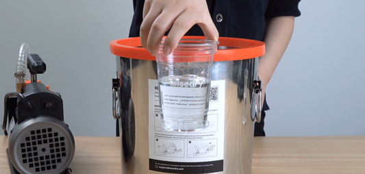 Air bubbles rising and popping in mixed resin inside a vacuum chamber.